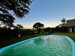 een zwembad in de tuin van een huis bij Cabana do Lago- Morro da Borússia in Osório