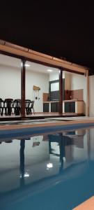 een zwembad met tafels en stoelen en een televisie bij Quincho Russo in Cerrillos