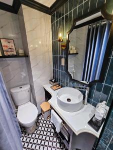 ein Badezimmer mit Toilette, Waschbecken und Spiegel in der Unterkunft Grand Dilly Inn Saigon Hotel - Ben Thanh Market in Ho-Chi-Minh-Stadt