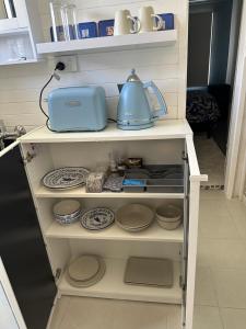 un estante con platos y un hervidor de agua. en Canberra Hospital Blue Daisy- Sleep & Go, en Phillip 21 fotos más
