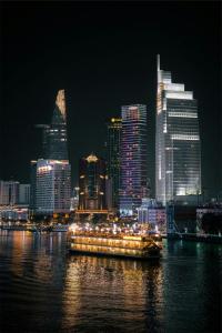 een boot in het water met een stad in de nacht bij shen hotel8 in Ho Chi Minh-stad