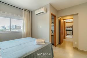 ein Schlafzimmer mit einem Bett und einem Fenster in der Unterkunft Apto em Cond. c/ Piscina em Goiânia KSP1304 in Goiânia + 11 Fotos