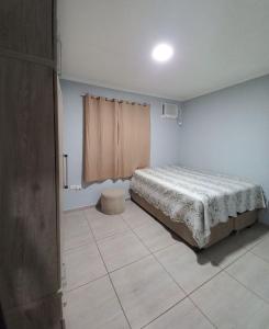 een slaapkamer met een bed in de hoek van een kamer bij Casa Aconchegante in Guarujá