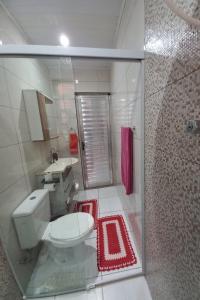 een badkamer met een toilet, een wastafel en een douche bij Casa Aconchegante in Guarujá +8 foto's