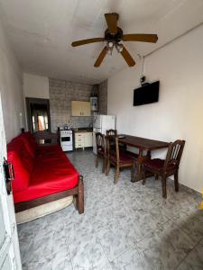 een woonkamer met een rode bank en een tafel bij Depto 2 ambientes A pasos del MAR in Mar de Ajó