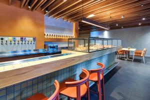 a restaurant with orange chairs and a counter with some pastries at lyf on Elizabeth Melbourne in Melbourne
