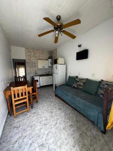 een woonkamer met een bank en een plafondventilator bij Depto 2 ambientes A pasos del MAR in Mar de Ajó