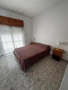 een slaapkamer met een bed, een tafel en een raam bij Depto 2 ambientes A pasos del MAR in Mar de Ajó +2 foto's
