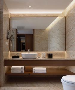 een badkamer met een wastafel en een spiegel bij Jinmanfu International Hotel in Huadu