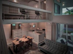 un soggiorno con tavolo e divano e una cucina di CORAL ISLAND 1棟貸し 天然ビーチまで徒歩5秒 ジャグジー付きVilla a Nago