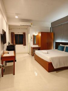 een slaapkamer met een bed, een bureau en een televisie bij Smile Court Pattaya by Mike Group in Pattaya +19 foto's
