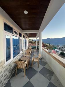 a porch with chairs and a view of the ocean at Maitreya Homestay in Tawang