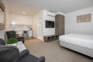 a bedroom with a bed and a living room and a kitchen at Newington Apartments in Ballarat