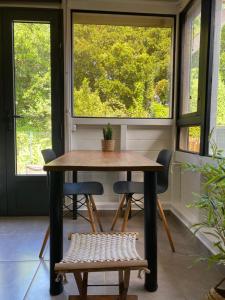a table and chairs in a room with windows at Villa cactus in Goyave