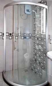 y baño con ducha y puerta de cristal. en Arusha Naaz Hotel, en Arusha
