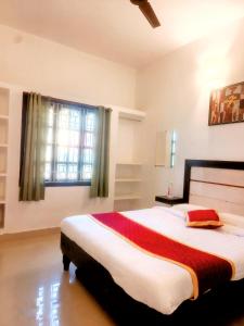 a bedroom with a large bed and a window at The Dreams sea view in Puducherry