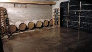 a row of wine barrels in a wine cellar at Finca Fraschetti in El Bolsón