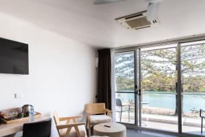 a living room with a view of a pool at HaKu in Brunswick Heads