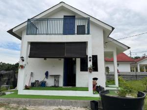 a white house with a balcony on top of it at Science and Astronomy Garden in Kampung Dengkil