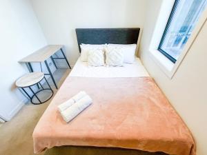 a small bedroom with a bed with an orange blanket at Sky Tower Views 2BR Retreat Wit h FREE Pool Gym in Auckland +29 photos