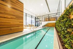 a swimming pool in a building with plants at Sky Tower Views 2BR Retreat Wit h FREE Pool Gym in Auckland