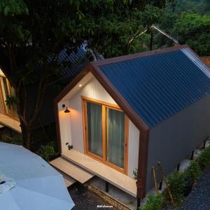 een klein huisje met een blauw dak bij กู๊ดวิวแคมป์ชะอม in Ban Bung Mai