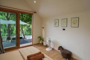 a living room with a large window and a fan at กู๊ดวิวแคมป์ชะอม in Ban Bung Mai +2 photos