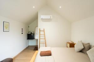 a bedroom with a ladder next to a bed at กู๊ดวิวแคมป์ชะอม in Ban Bung Mai
