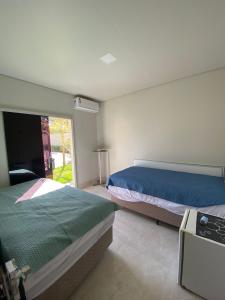 a bedroom with two beds and a window at Casas Paradisiaca aleatória l , ll ou lll ou lV Pagamento Automática in Caldas Novas +15 photos