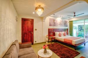 卡兰古特Dimaru Boutique Courtyard的一间卧室，里面有一张床、一张沙发和一张桌子