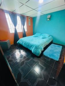 une chambre avec un lit dans une pièce bleue dans l'établissement Casa Colores, à Murillo