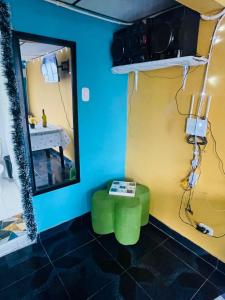 une salle de bain avec un tabouret vert et un miroir dans l'établissement Casa Colores, à Murillo