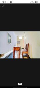 a living room with a wooden table and a chair at Mm Home Stay in Coimbatore