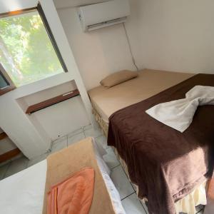 a small room with two beds and a window at Vila morro casas de praia in Cairu
