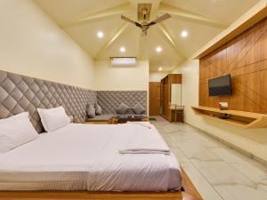 a bedroom with a large bed and a flat screen tv at Natural resort in Panhāla