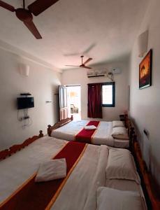 a room with three beds in it with a window at The Dreams sea view in Puducherry +13 photos