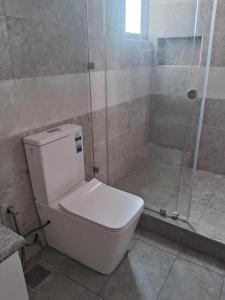 ein weißes WC im Bad mit Dusche in der Unterkunft Lavania Ocean View Residencies in Watumulla