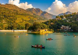 eine Gruppe von Menschen in Booten auf einem See in der Unterkunft Kanara Hotel in Bhīm Tāl