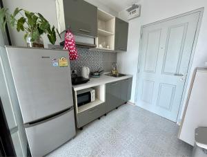 a small kitchen with a refrigerator and a sink at Z cape 1 two two in Ban Thalat Choeng Thale