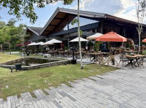 a restaurant with tables and umbrellas in front of it at Z cape 1 two two in Ban Thalat Choeng Thale