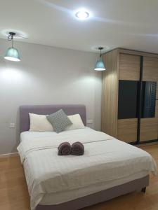 een slaapkamer met een groot bed met twee donuts erop bij Nordic Residences in Melaka