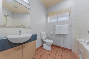 een witte badkamer met een wastafel en een toilet bij Spa Haven 18B in Airlie Beach