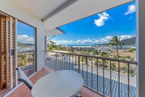 een balkon met een tafel en uitzicht op de oceaan bij Spa Haven 18B in Airlie Beach