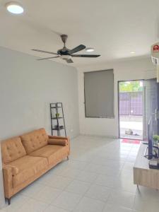 een woonkamer met een bank en een plafondventilator bij Nordic Residences in Melaka
