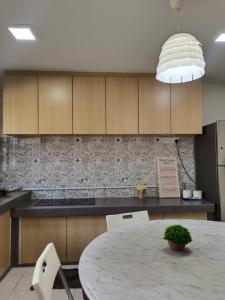 een keuken met een tafel en een hanglamp bij Nordic Residences in Melaka
