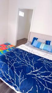a bedroom with a bed with a blue comforter at Pretty bedroom with shared bathroom in Hacienda Heights