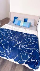 a bed with a blue blanket with a tree design at Pretty bedroom with shared bathroom in Hacienda Heights