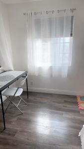 a desk and a chair in a room with a window at Pretty bedroom with shared bathroom in Hacienda Heights