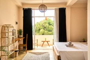 een slaapkamer met een bed en een groot raam bij Casa Banana in Weligama