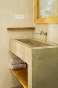 een badkamer met een wastafel, een spiegel en handdoeken bij Casa Banana in Weligama